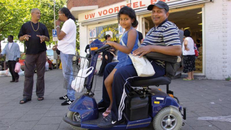 man op scootmobiel met dochter op schoot